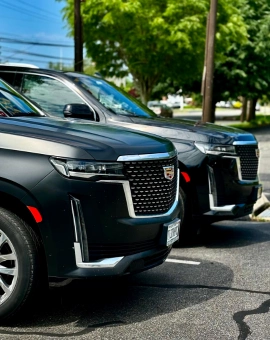 Two black luxury SUVs parked together